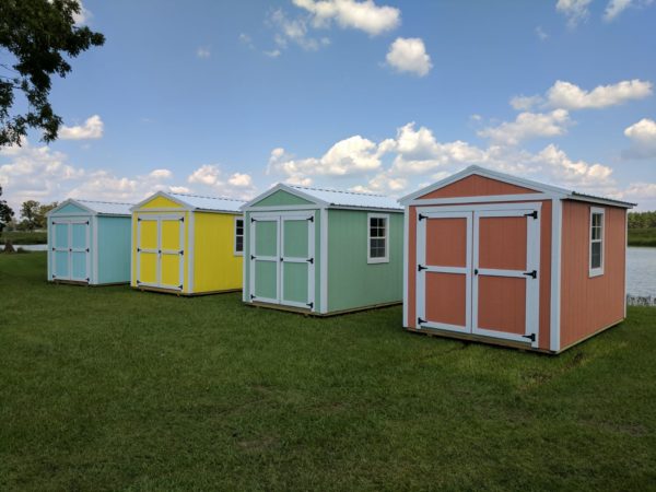 four-sheds-with-bright-blue-yellow-green-and-coral-paint-on-exterior